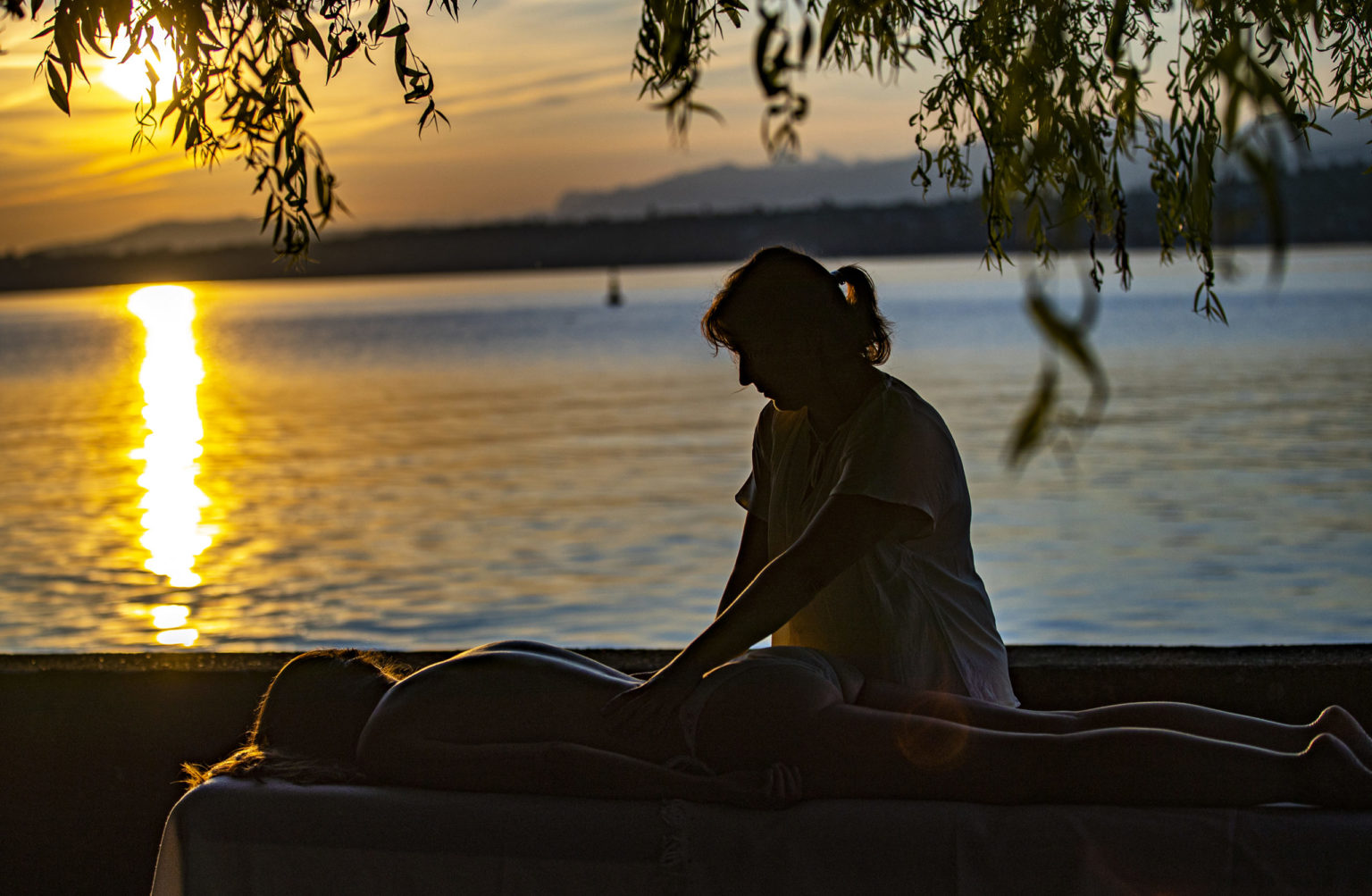 Zahra Chouitar en séance de biomassage énergétique au bord de l'eau, au coucher du soleil